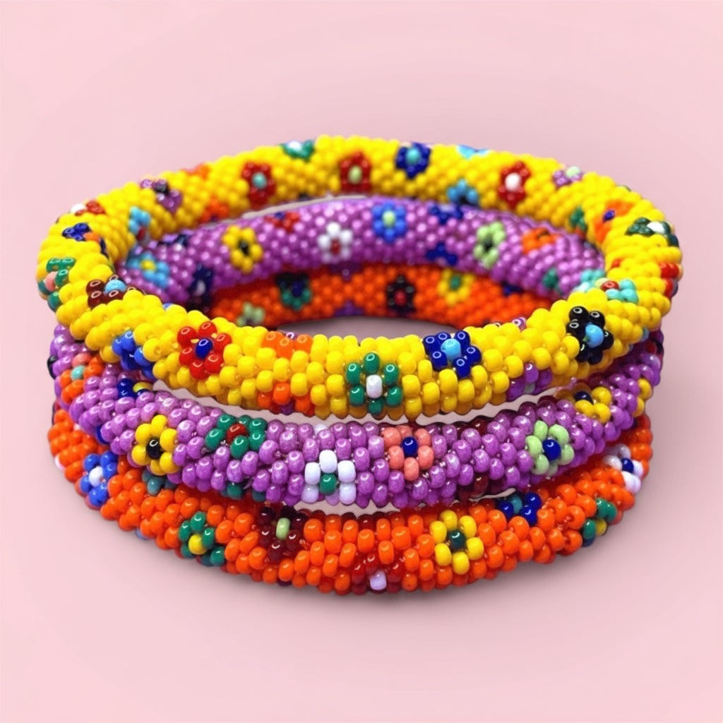 Stack of colorful beaded bracelets on a pink background - Beadzy 