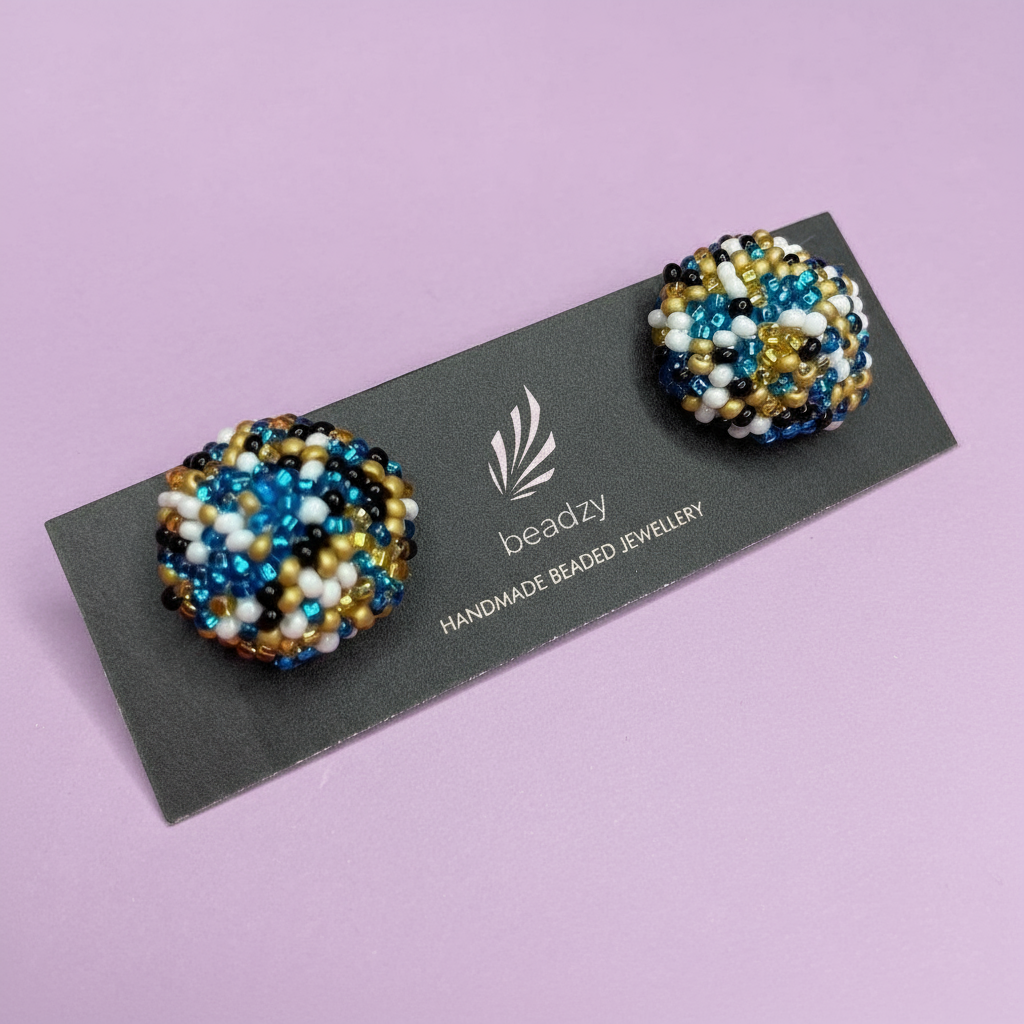 Beaded earrings on a 'beadzy' branded card against a purple background - Beadzy