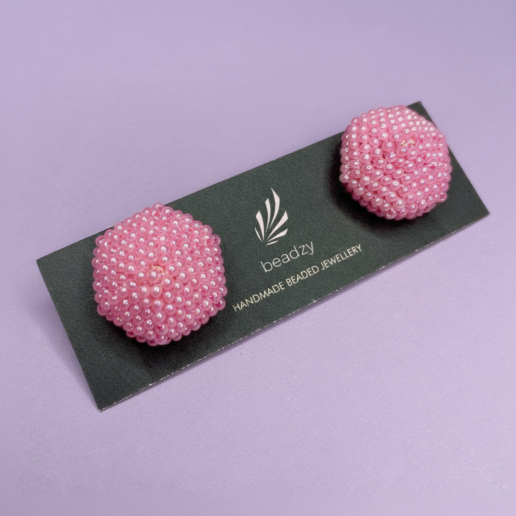 Pink beaded earrings on a black card with 'beadzy' branding against a purple background - Beadzy