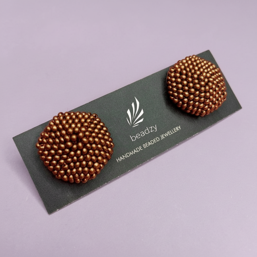 Pair of beaded earrings on a 'beadzy' branded card against a light purple background - Beadzy