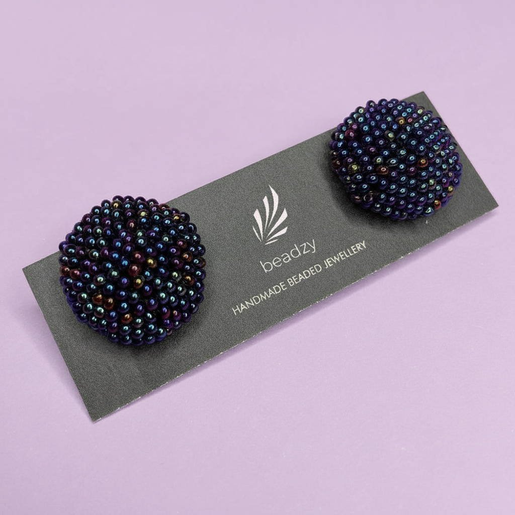 Pair of blue beaded earrings on a 'beadzy' branded card against a light purple background - Beadzy