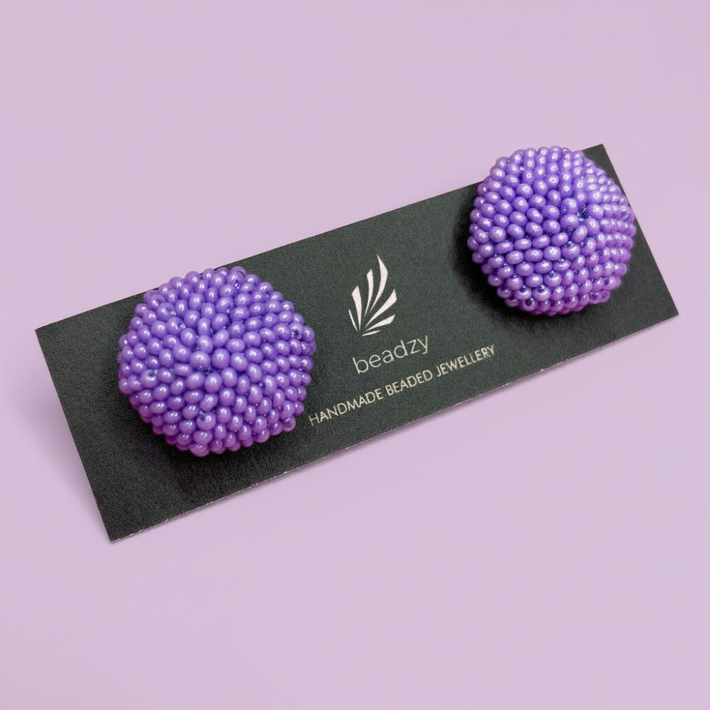 Purple beaded earrings on a black card with 'beadzy' branding against a light purple background - Beadzy