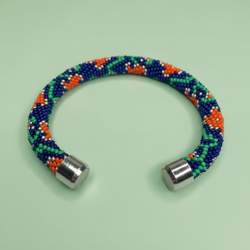 Beaded bracelet with blue, green, and orange beads on a light green background - Beadzy