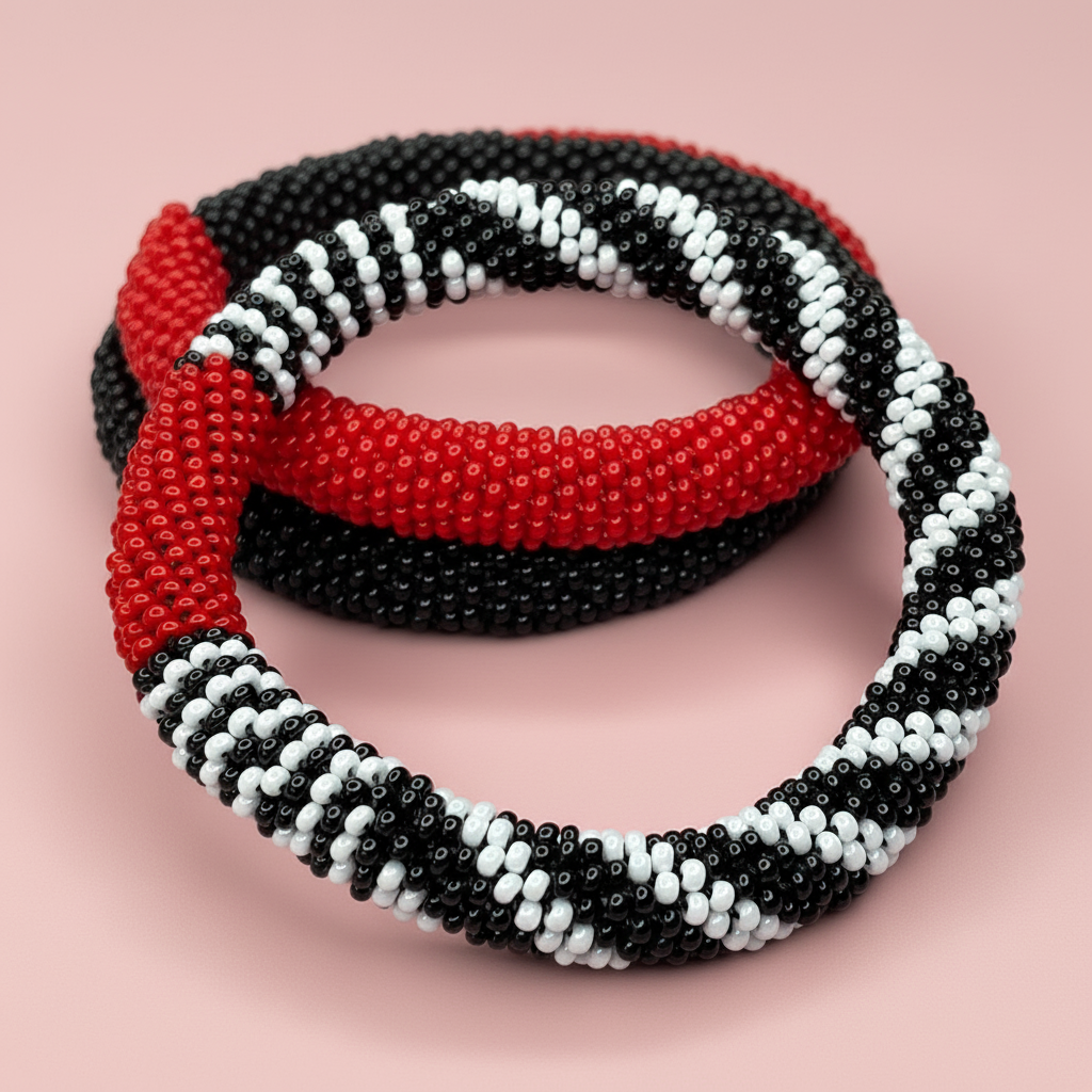 Three beaded bracelets in red, black, and white on a pink background - Beadzy