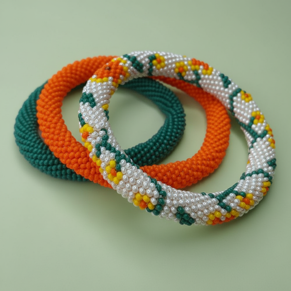 Three beaded bracelets in orange, green, and white with yellow accents on a light green background. - Beadzy