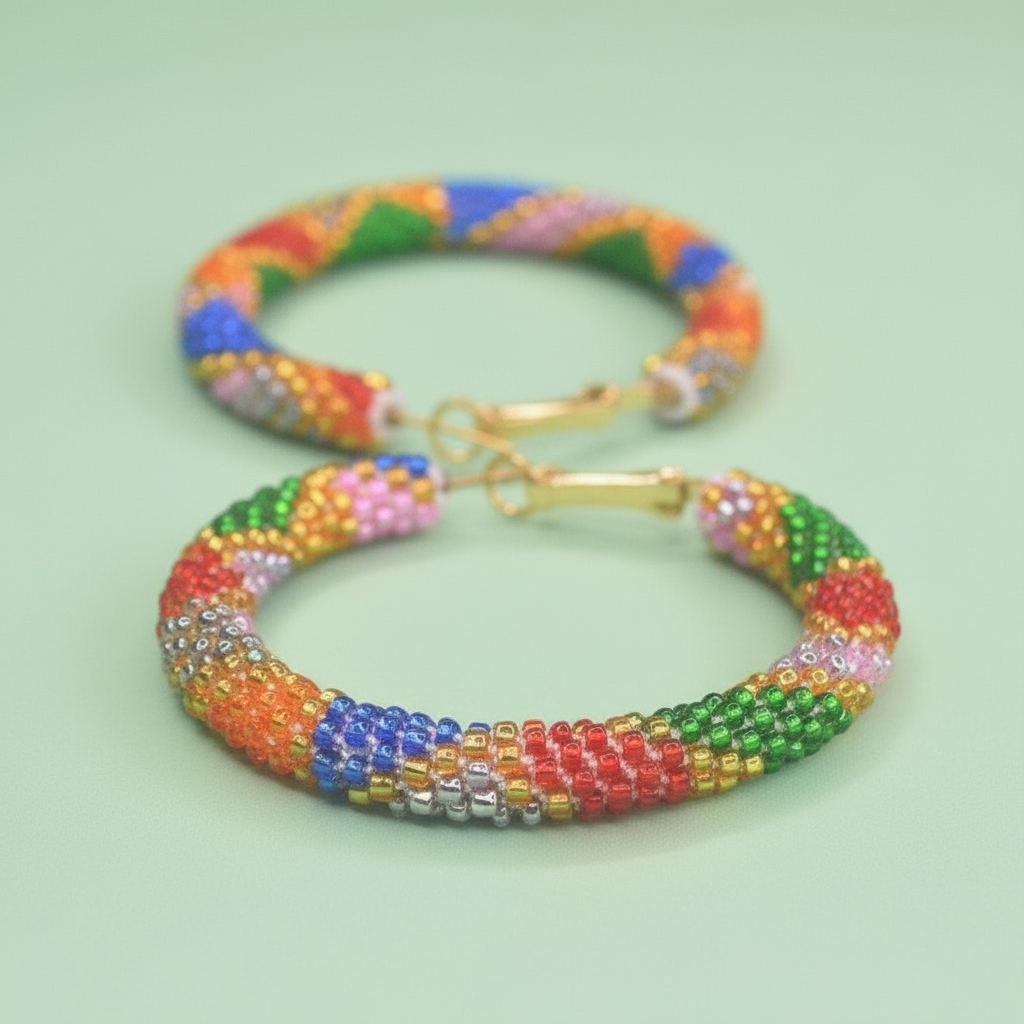 Colorful beaded hoop earrings with a gold clasp on a light green background - Beadzy