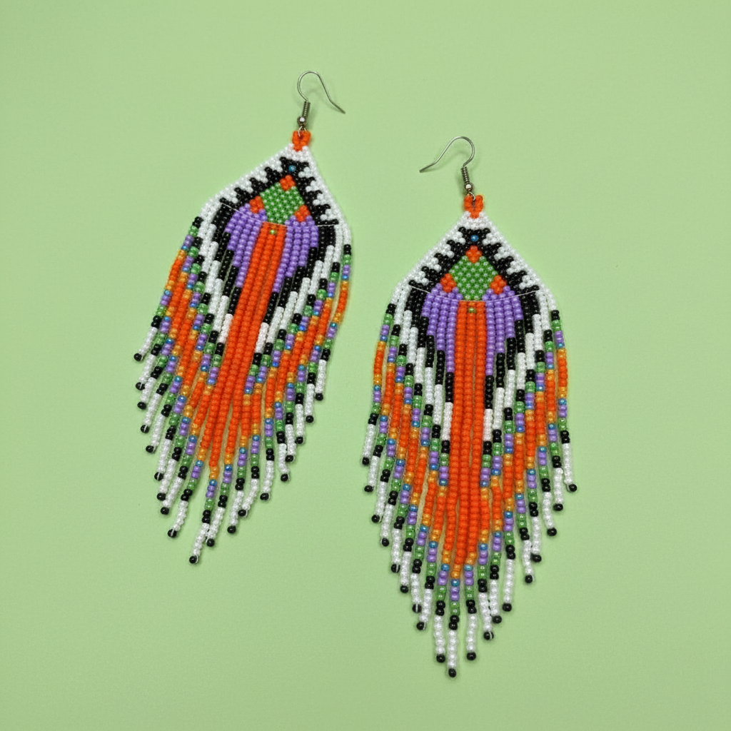 Beaded tassel earrings with orange, black, white, and green beads on a light green background - Beadzy