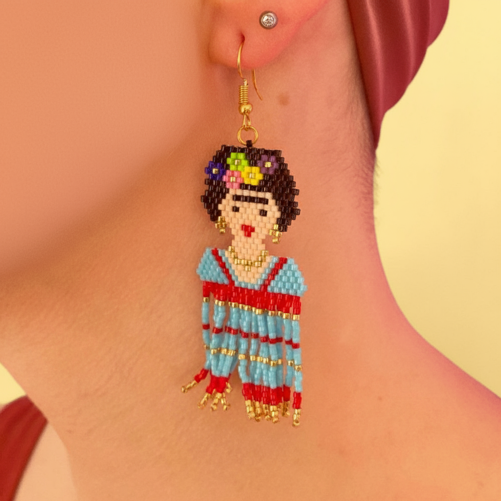 Earring with a detailed design of Frida a colorful outfit, worn by a person.  - Beadzy