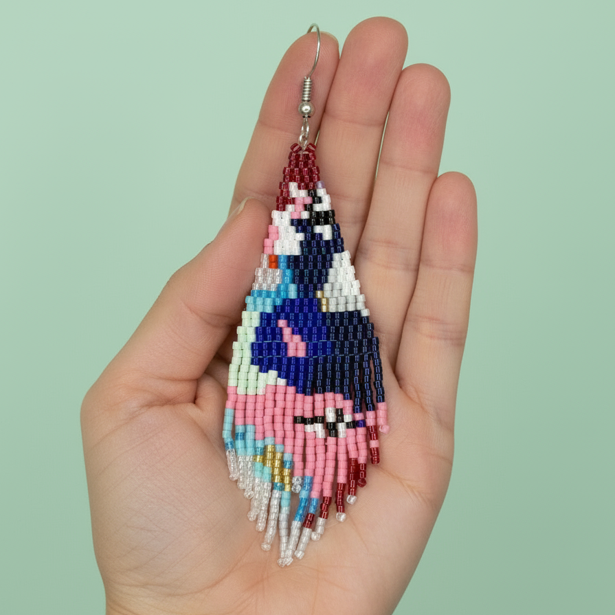 Colorful beaded earrings held in a hand against a light green background