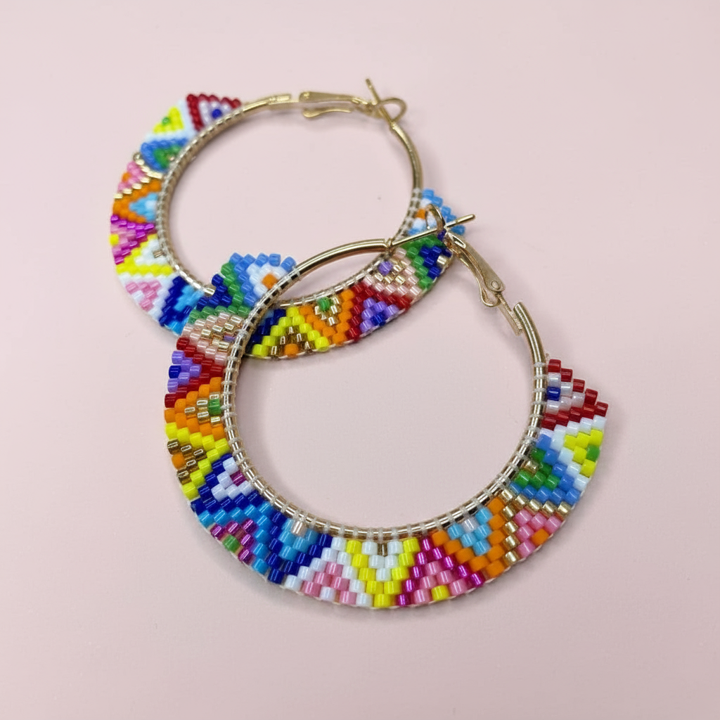Colorful beaded hoop earrings on a pink background - Beadzy