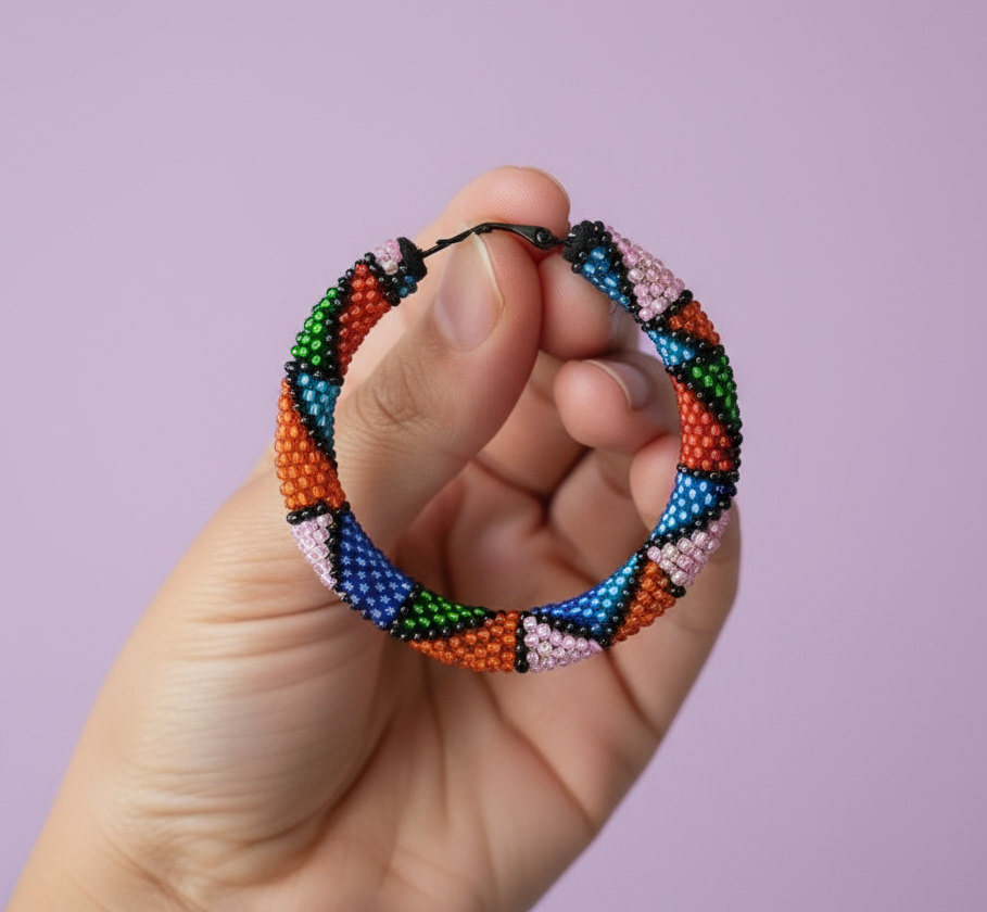 Hand holding a colorful beaded hoop earring against a light purple background - Beadzy
