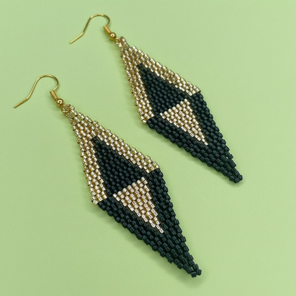 Black and gold beaded earrings on a light green background - Beadzy
