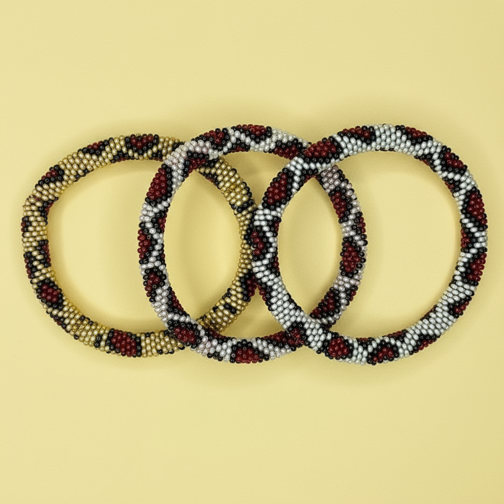 Three leopard patten beaded bracelets in brown, beige, and black on a yellow background - Beadzy