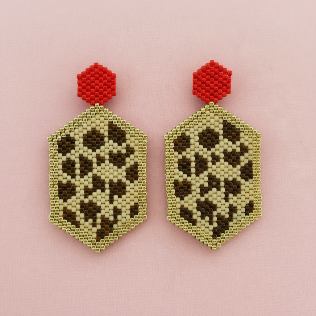 Hexagonal beaded earrings with leopard print design and red tops on a pink background - Beadzy