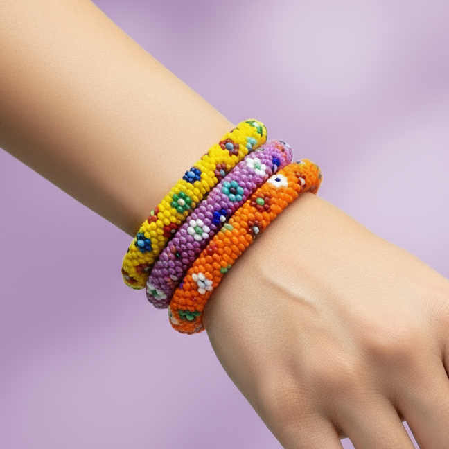 Colorful beaded bracelets on a wrist against a light purple background - Beadzy