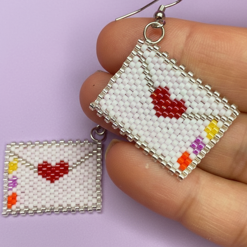 Beaded earrings shaped like envelopes with red hearts on a purple background - Beadzy