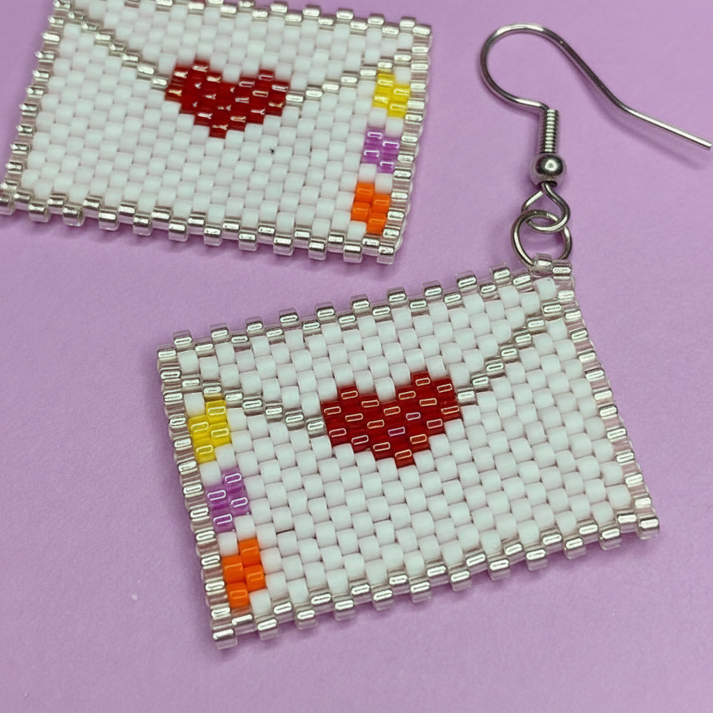 Beaded earrings with heart designs on a purple background - Beadzy