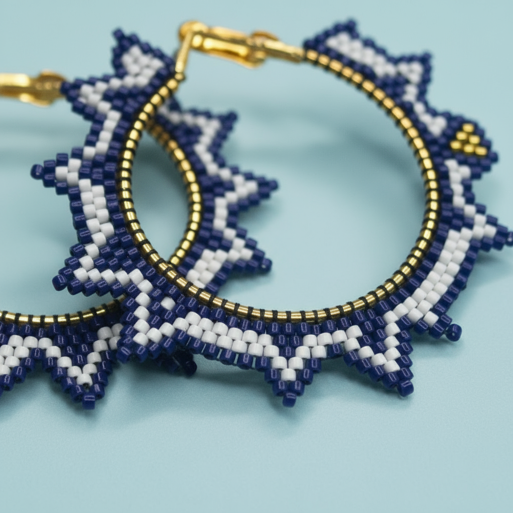 Beaded earrings with blue, white, and gold design on a light blue background - Beadzy