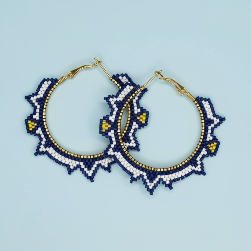 Pair of beaded hoop earrings with blue, white, and gold design on a light blue background - Beadzy