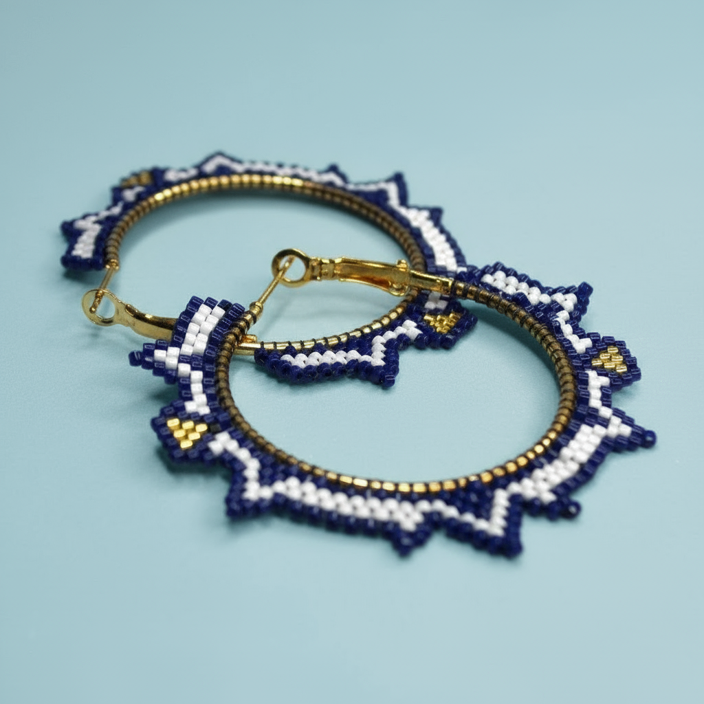 Pair of beaded earrings with blue, white, and gold design on a light blue background - Beadzy