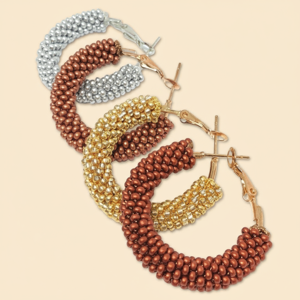Set of hoop earrings in gold, bronze, and silver on a beige background - Beadzy