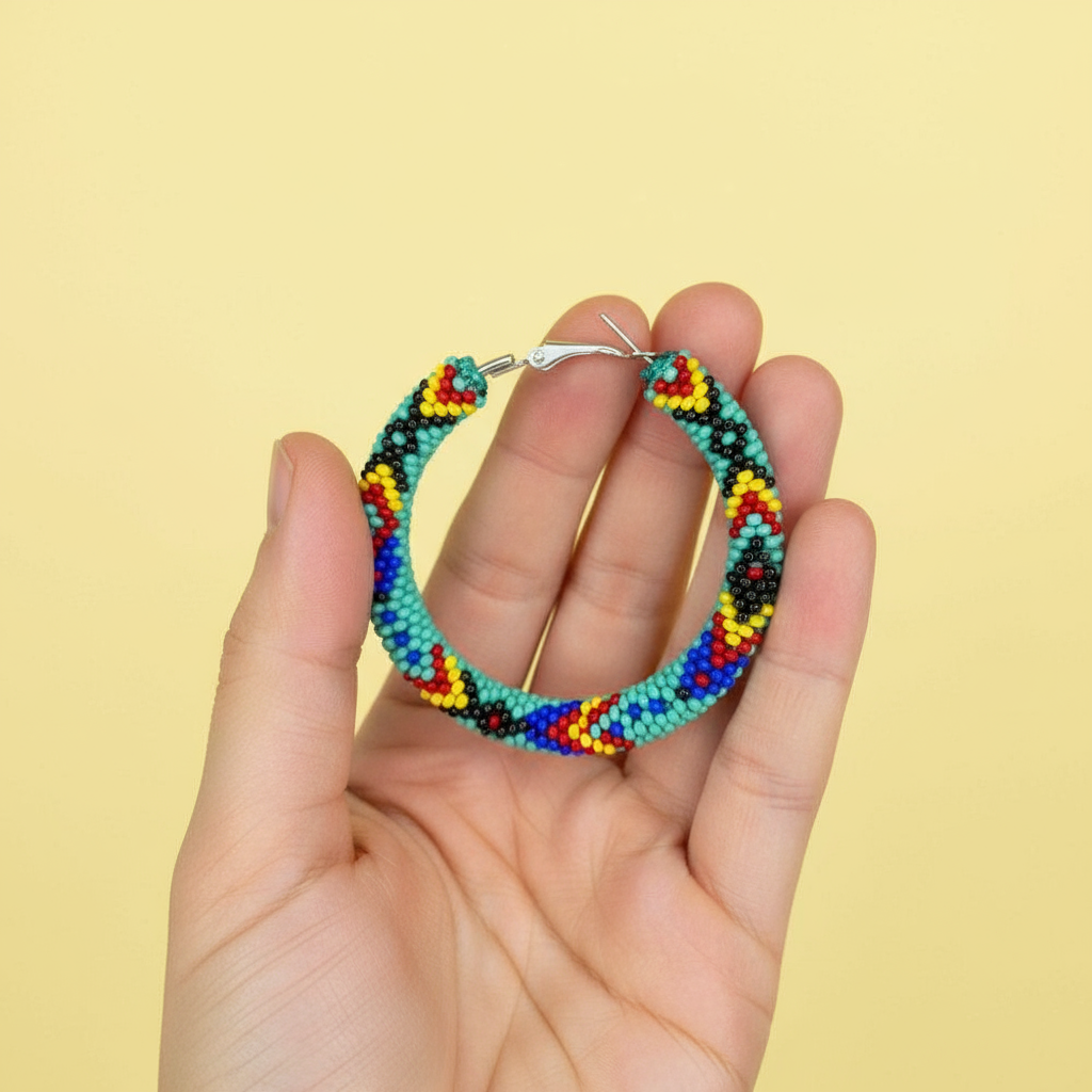 Colorful beaded hoop earrings held in a hand against a yellow background - Beadzy