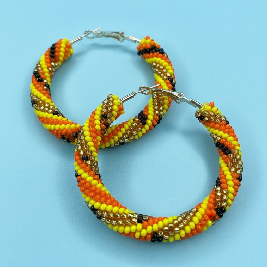 Beaded hoop earrings with orange, yellow, and black pattern on a blue background - Beadzy