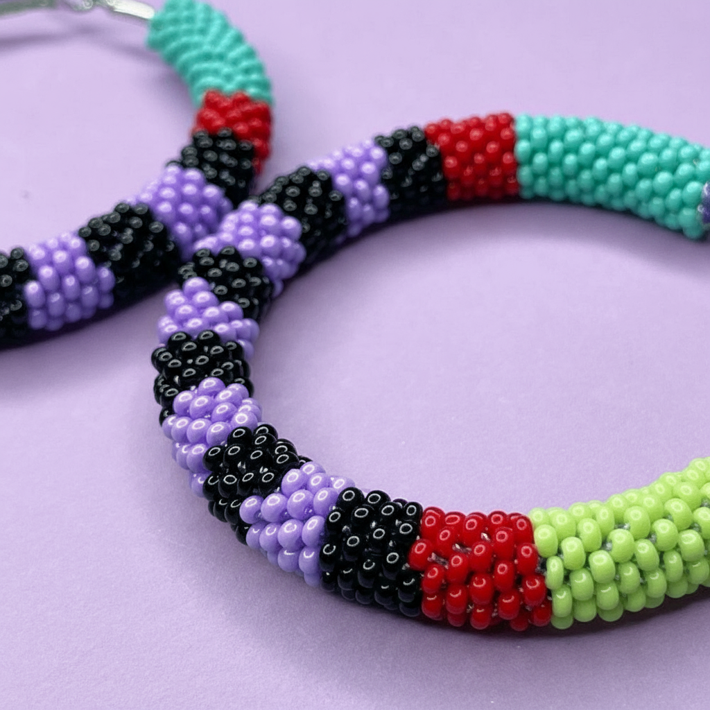 Colorful beaded hoop earrings with black, red, green, and purple beads on a light purple background - Beadzy