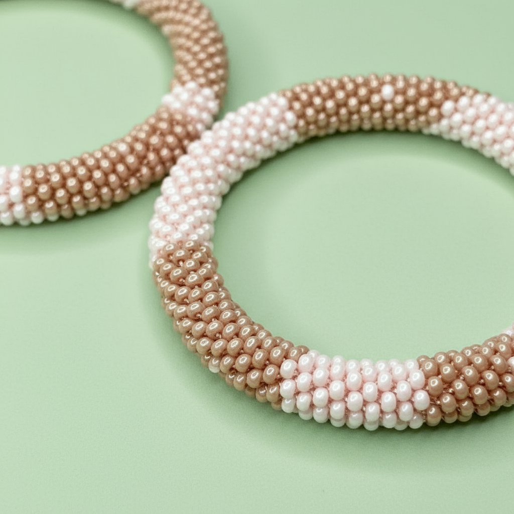 Pair of beaded hoop earrings in pink and beige on a light green background - Beadzy