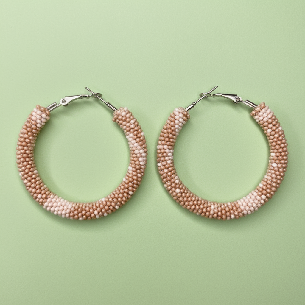 Pair of beaded hoop earrings on a light green background - Beadzy