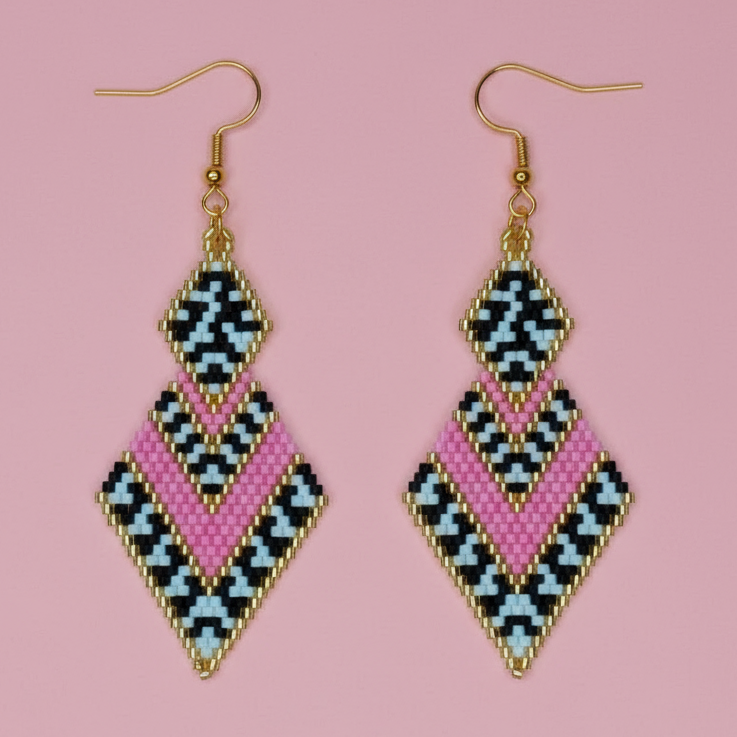 Pair of geometric earrings with pink, blue, and black pattern on a pink background - Beadzy
