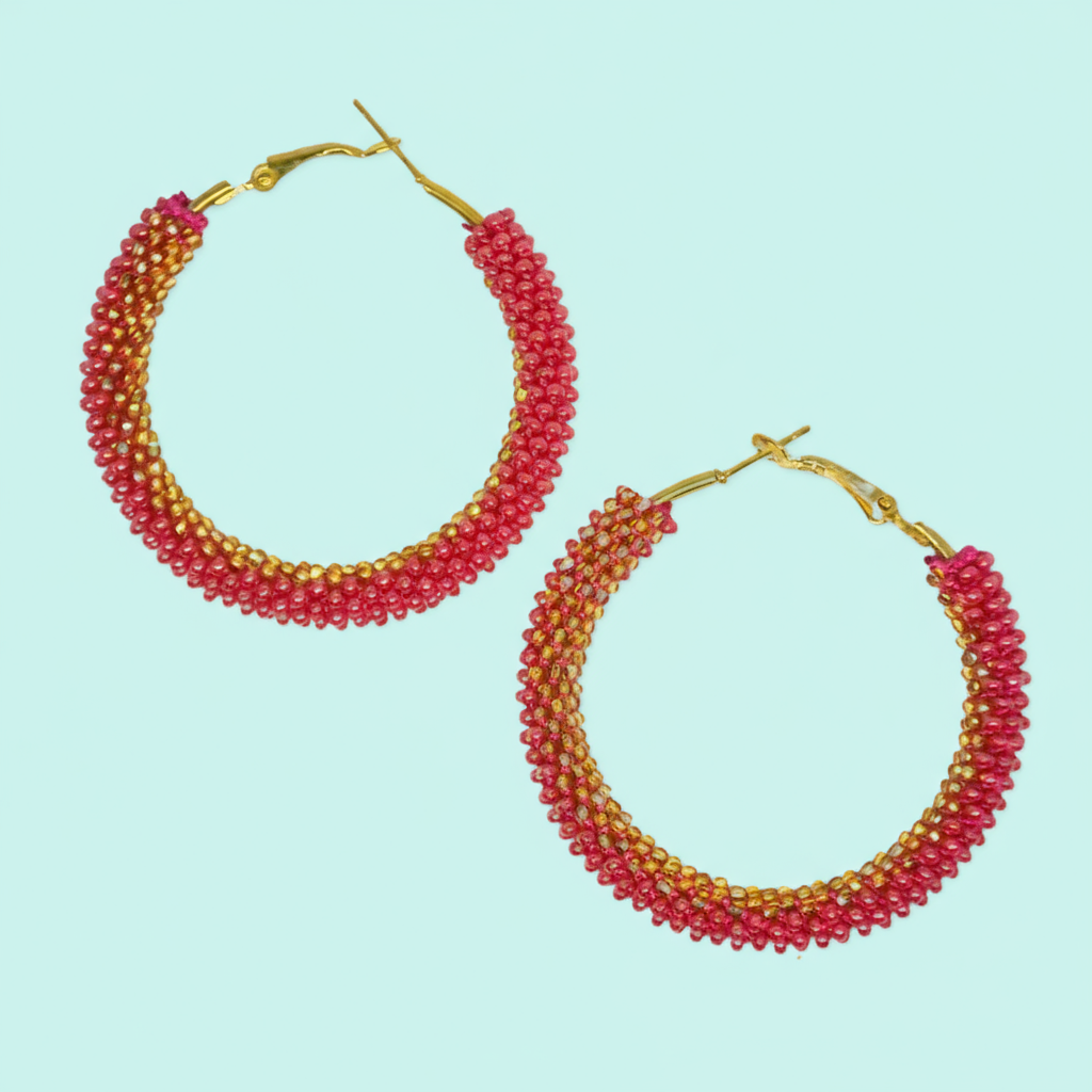 Pair of beaded hoop earrings with gold accents on a light blue background - Beadzy