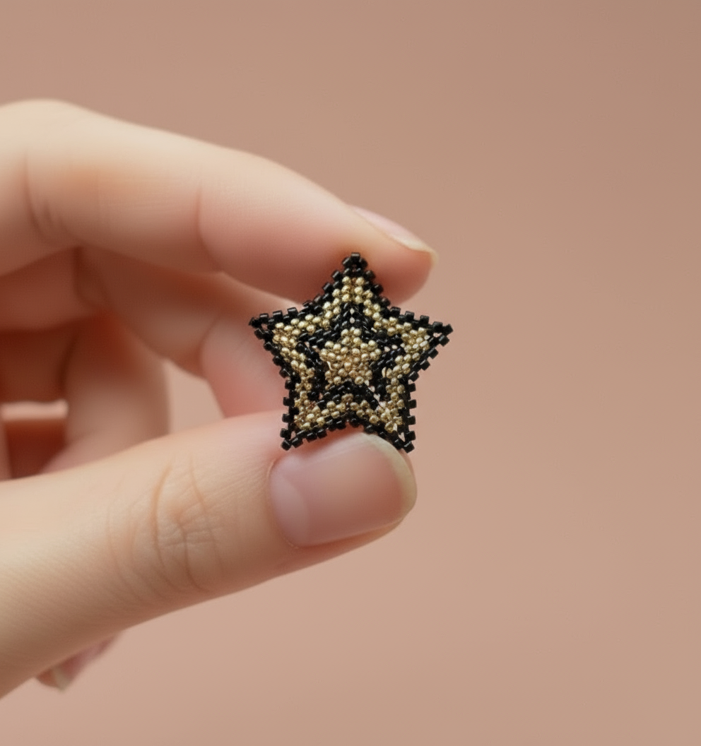 Hand holding a beaded star against a beige background - Beadzy
