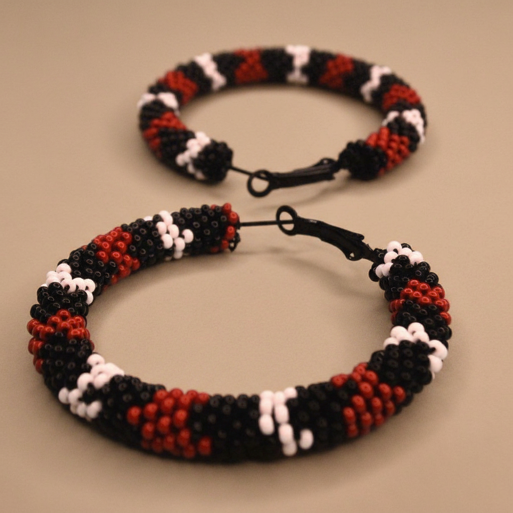 Beaded hoop earrings with red, black, and white pattern on a beige background - Beadzy