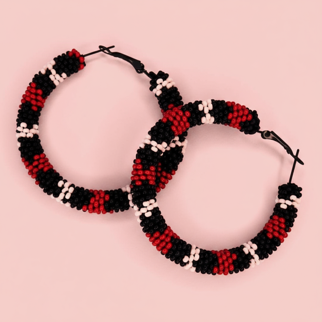 Pair of beaded hoop earrings in red, black, and white on a pink background - Beadzy