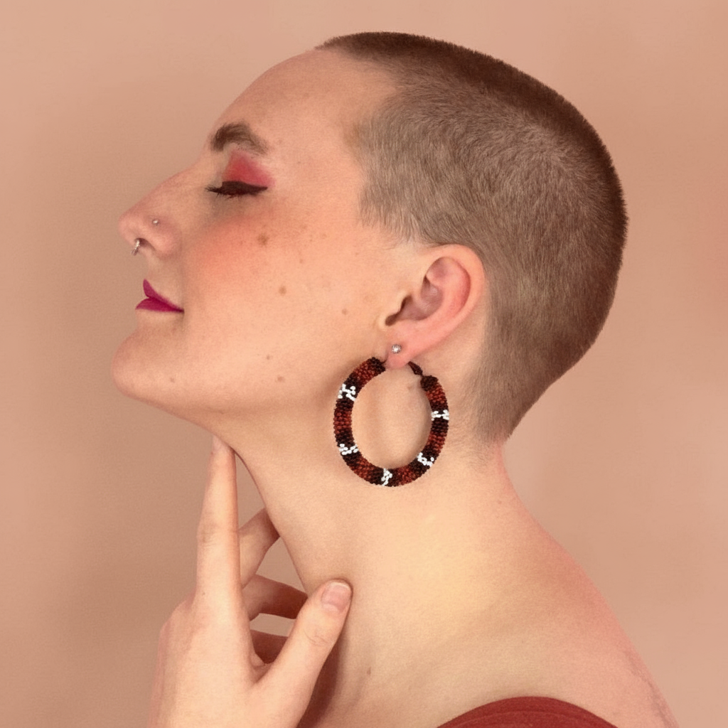 Woman wearing large hoop earrings with a neutral background - Beadzy