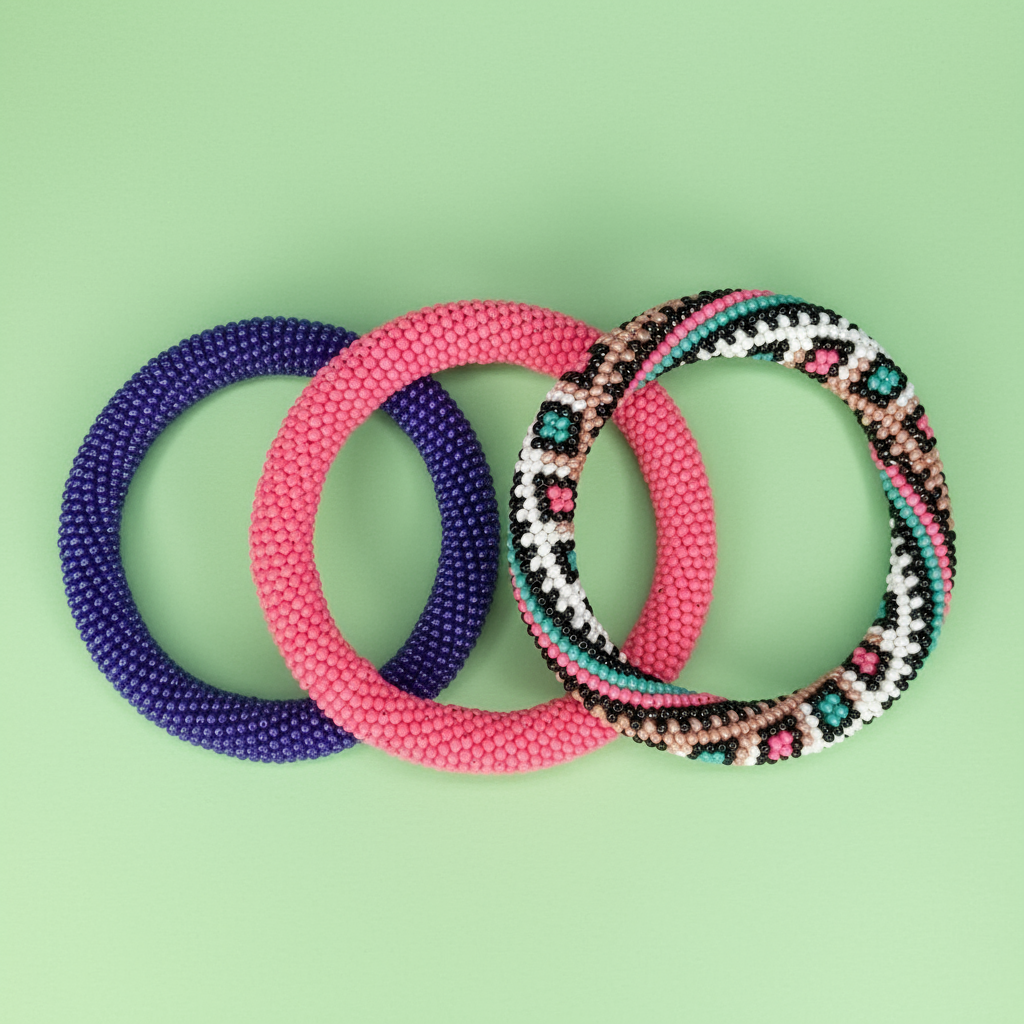 Three beaded rope bracelets in purple, pink, and multicolor on a green background - Beadzy 