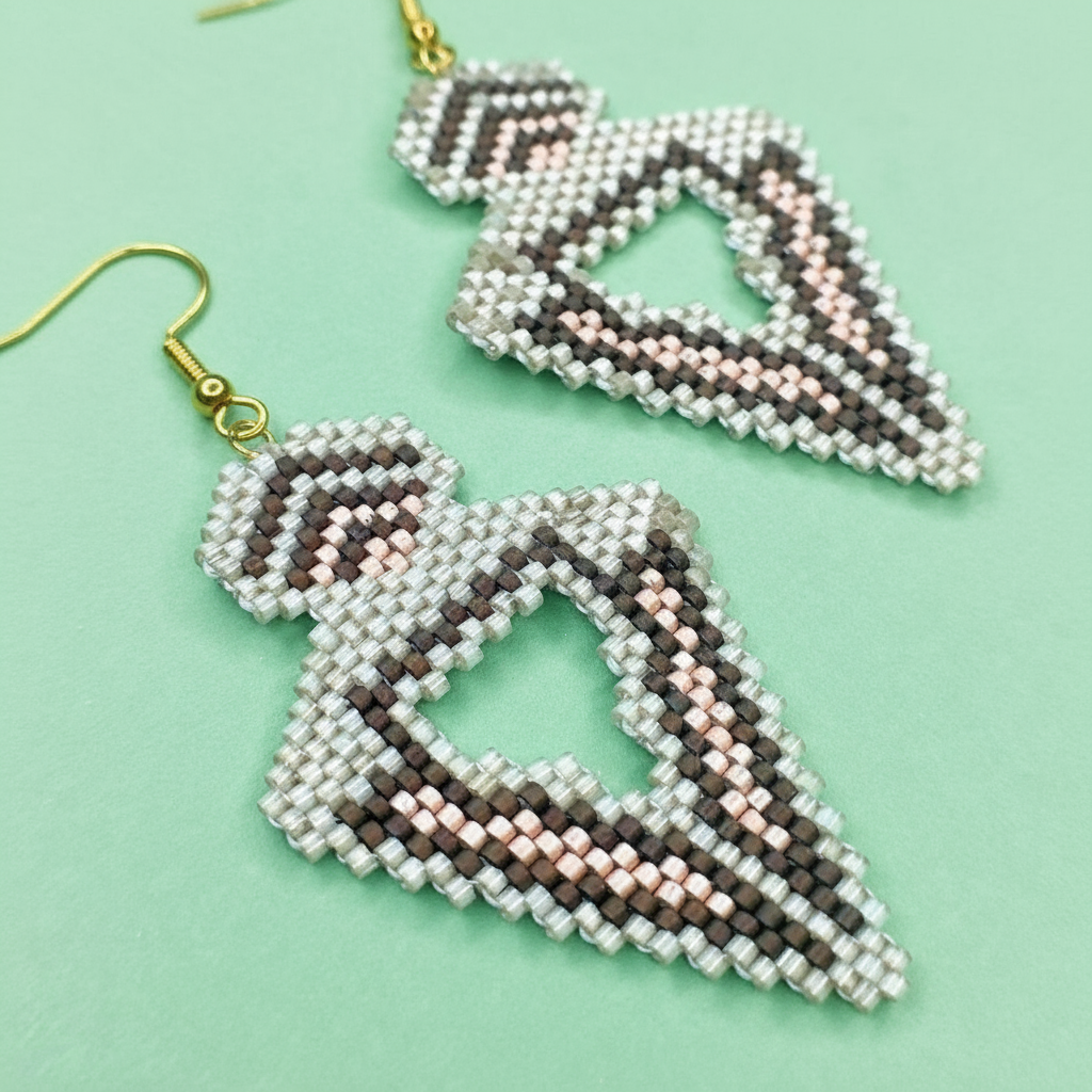 Beaded triangle-shaped earrings on a light green background - Beadzy