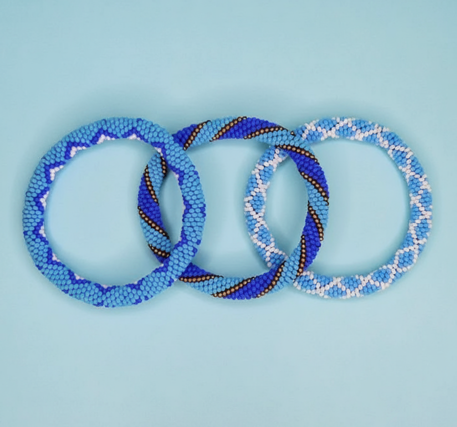 Three blue beaded bracelets on a light blue background - Beadzy