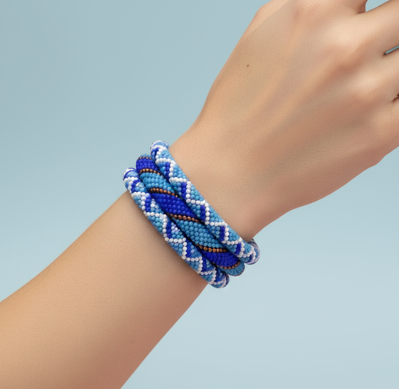 Blue braided bracelet on a wrist against a light blue background -Beadzy